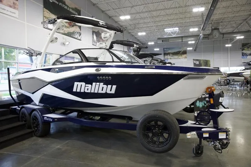Slide: The Image of 2025 Malibu 22 LSV boat displayed in a showroom, featuring sleek design and modern features. - 3