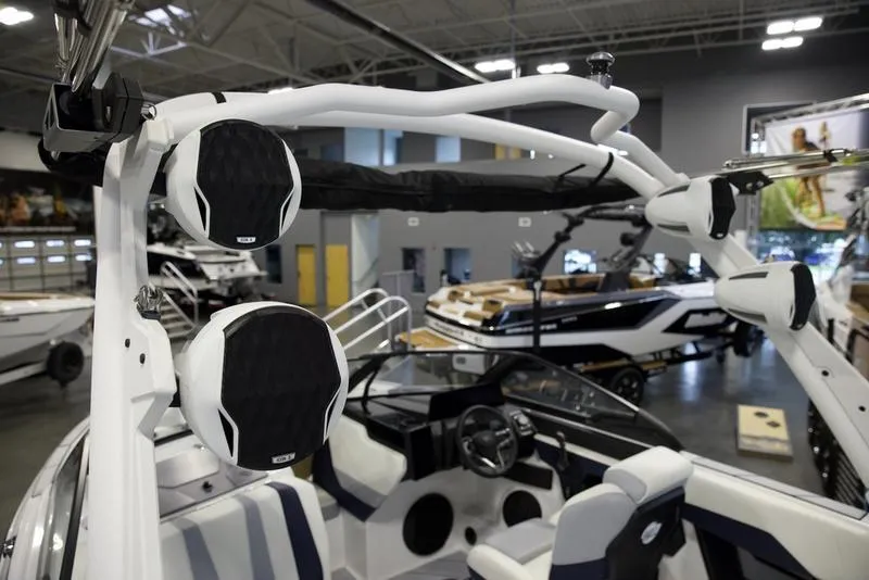 Slide: The Image of 2025 Malibu 22 LSV boat interior with speakers and seating in showroom. - 8