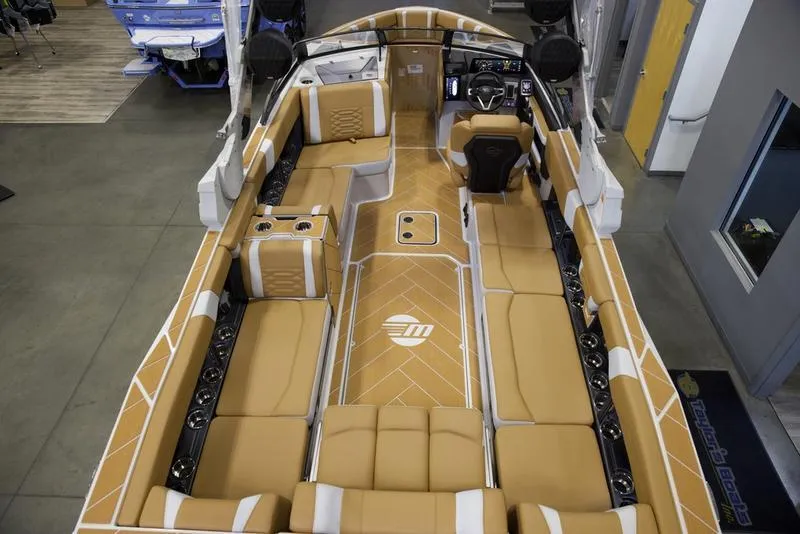 Slide: The Image of 2025 Malibu 26 LSV boat interior with tan seating and modern design. - 12