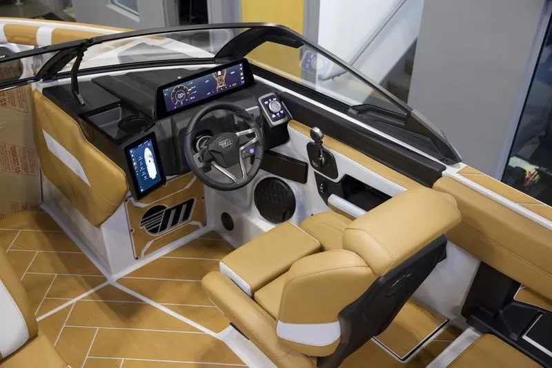 Slide: The Image of 2025 Malibu 26 LSV boat interior with modern dashboard and tan seating. - 14