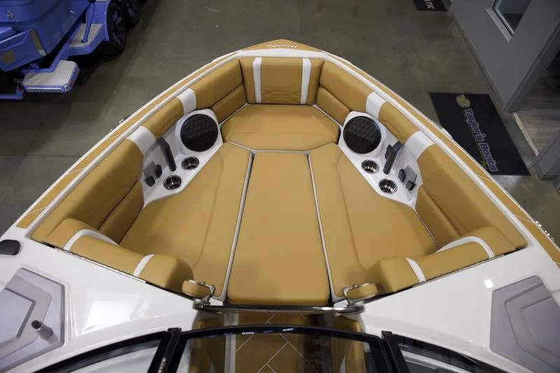 Slide: The Image of 2025 Malibu 26 LSV boat interior with tan seating and built-in speakers. - 19