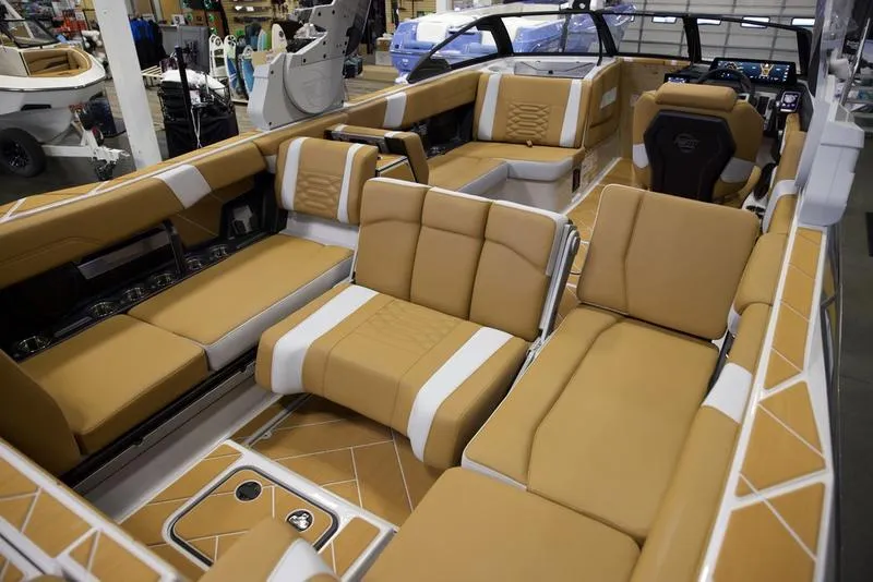 Slide: The Image of Luxurious interior of 2025 Malibu 26 LSV boat with tan and white seating. - 22