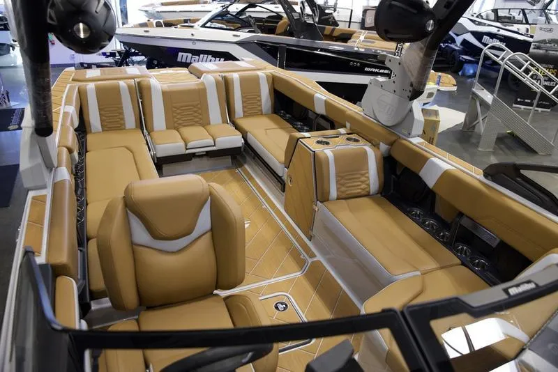 Slide: The Image of Luxurious interior of 2025 Malibu 26 LSV boat with tan and white seating. - 23