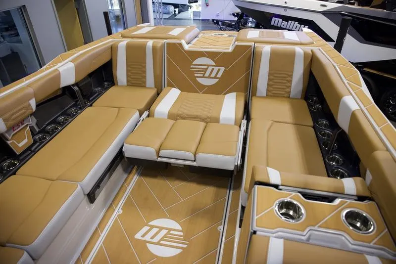 Slide: The Image of Luxurious interior of 2025 Malibu 26 LSV boat with tan and white seating. - 27