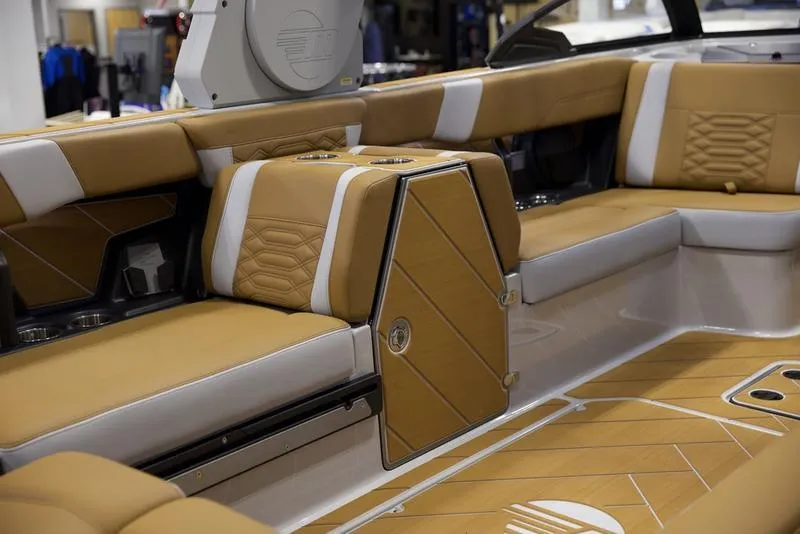 Slide: The Image of 2025 Malibu 26 LSV boat interior with tan and white seating. - 29