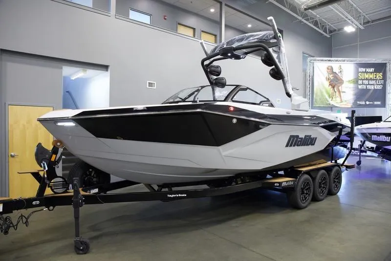 Slide: The Image of 2025 Malibu 26 LSV boat displayed indoors on a trailer. - 4