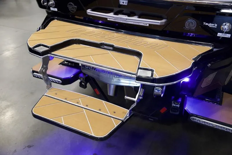 Slide: The Image of 2025 Malibu 26 LSV boat swim platform with LED lighting and teak finish. - 6