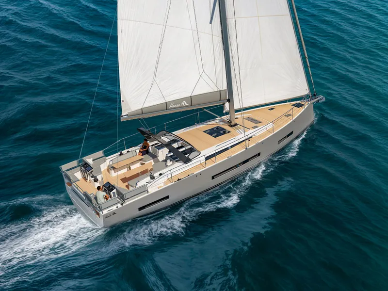 Slide: The Image of 2025 Hanse 590 yacht sailing on open sea, showcasing sleek design and spacious deck. - 48