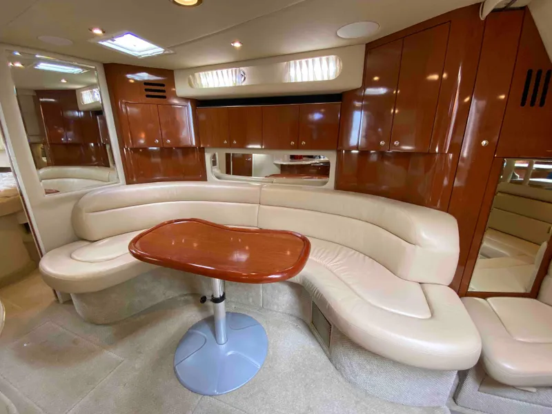 Slide: The Image of Luxurious interior of 2002 Sea Ray 380 Sundancer with curved seating and wooden table. - 13