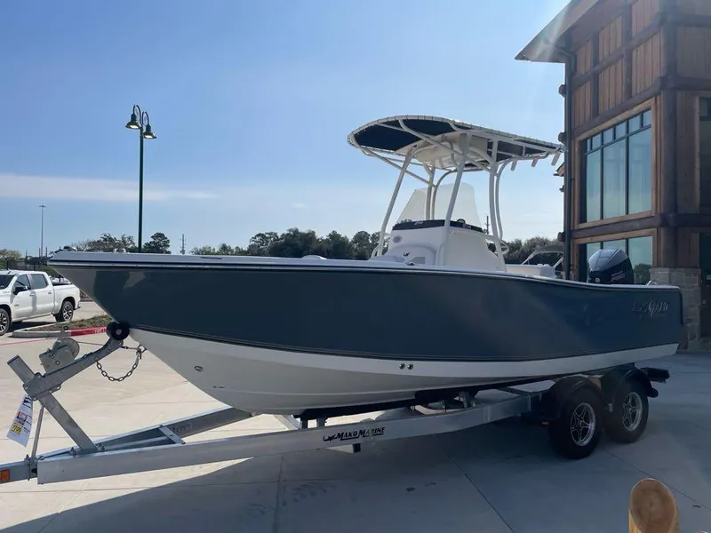 The Image of 2024 Mako 214 CC boat on trailer, parked outdoors near a building. - 0