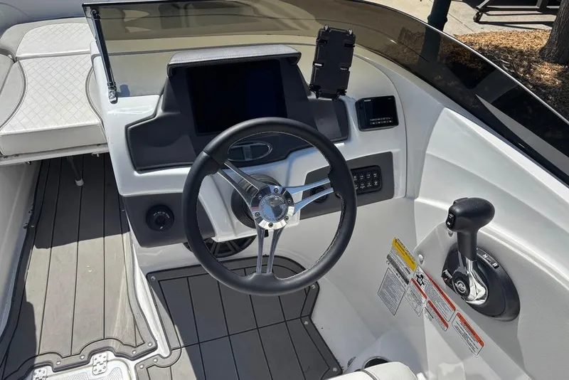 Slide: The Image of 2024 Tahoe 210 Si Limited boat cockpit with steering wheel and control panel. - 11