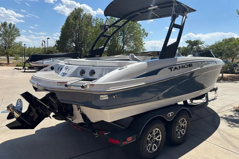Slide: The Image of 2024 Tahoe 210 Si Limited boat on trailer, parked outdoors under clear sky. - 3