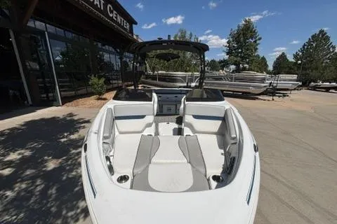 Slide: The Image of 2024 Tahoe 210 Si Limited boat with sleek design, parked outdoors under clear skies. - 4