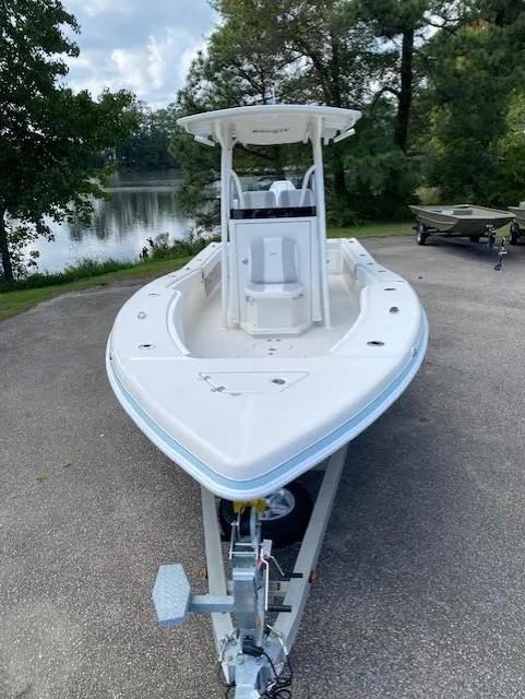 Slide: The Image of 2024 Ranger 2600 Bay boat on trailer, parked near a scenic lake. - 2