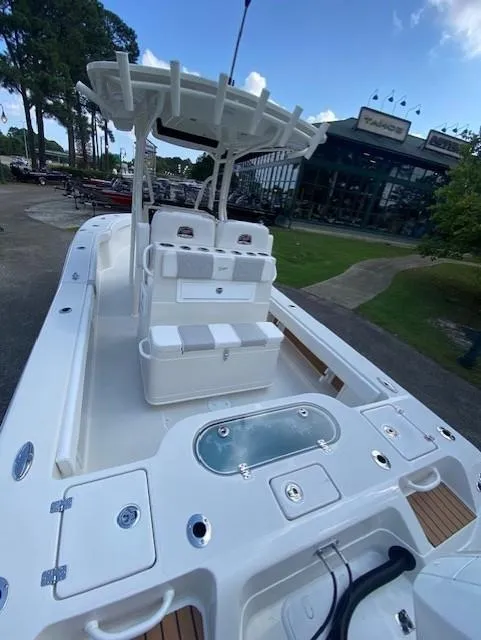 Slide: The Image of 2024 Ranger 2600 Bay boat with spacious deck and seating, parked outdoors. - 4