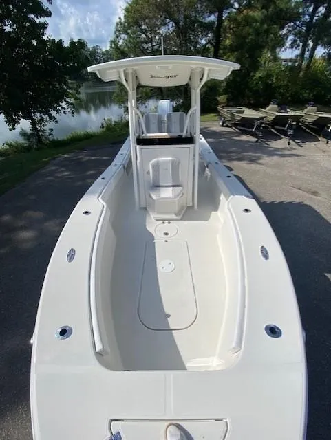 Slide: The Image of 2024 Ranger 2600 Bay boat, sleek design, spacious deck, parked near a serene lake. - 6