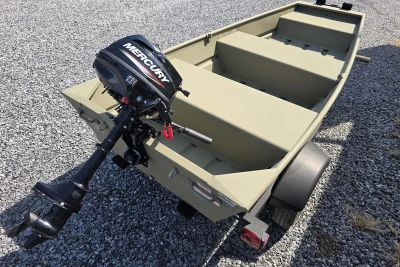 Slide: The Image of 2025 Tracker Grizzly 10 Jon boat with Mercury outboard motor on gravel. - 8