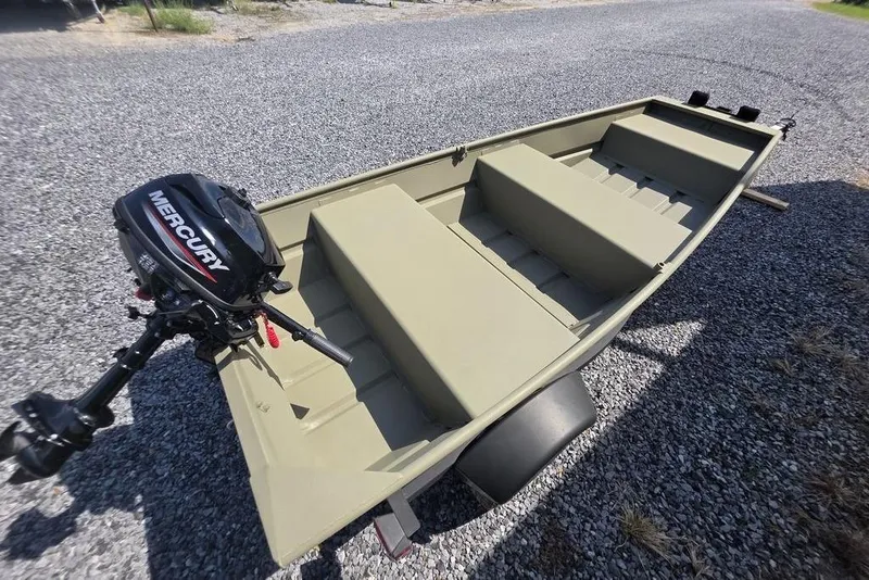 Slide: The Image of 2025 Tracker Grizzly 10 Jon boat with Mercury outboard motor on gravel surface. - 9