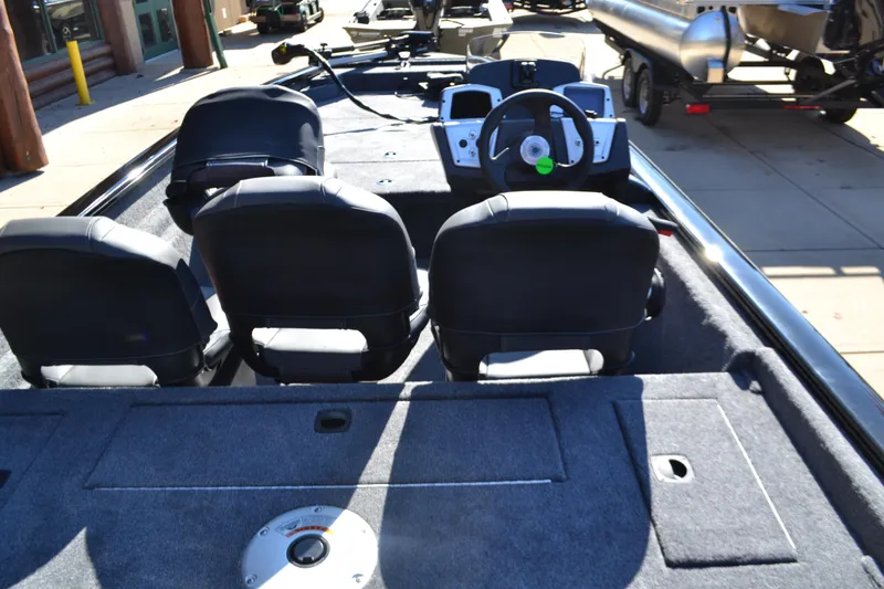 Slide: The Image of 2025 Tracker Pro Team 175 Crappie Edition boat interior with steering wheel and seating. - 2