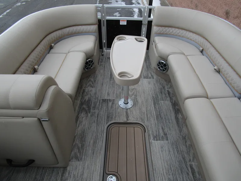 Slide: The Image of 2024 Ranger Reata 223C boat interior with beige seating and central table. - 11