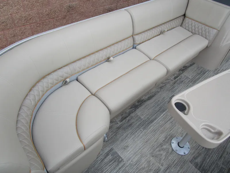Slide: The Image of 2024 Ranger Reata 223C boat interior with beige cushioned seating and table. - 12