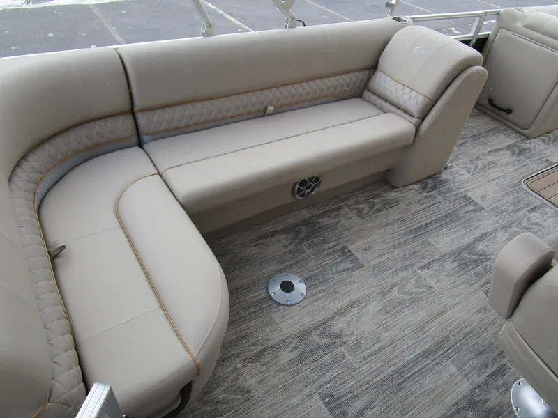 Slide: The Image of 2024 Ranger Reata 223C boat interior with beige seating and wood-patterned flooring. - 16