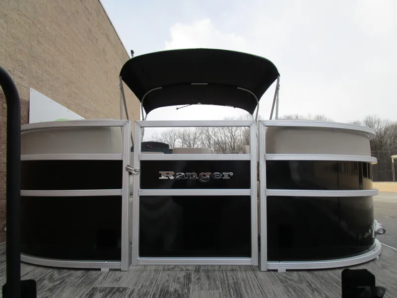 Slide: The Image of 2024 Ranger Reata 223C pontoon boat with black and white exterior, docked outdoors. - 4
