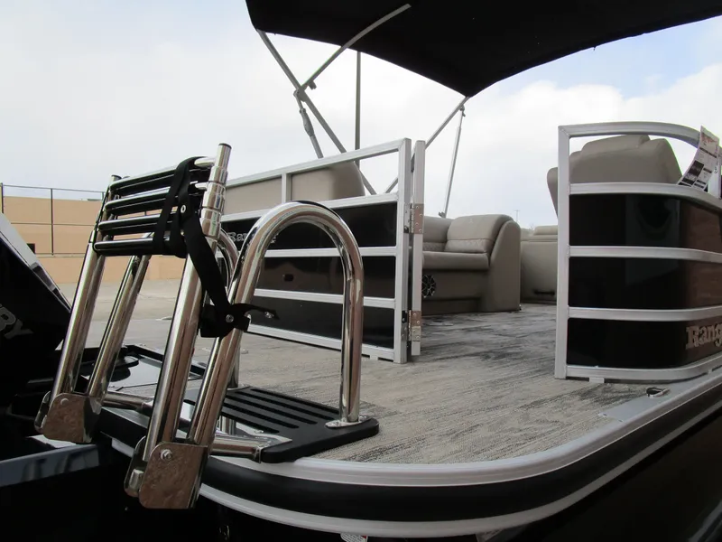 Slide: The Image of 2024 Ranger Reata 223C pontoon boat with seating and ladder, under a canopy. - 7