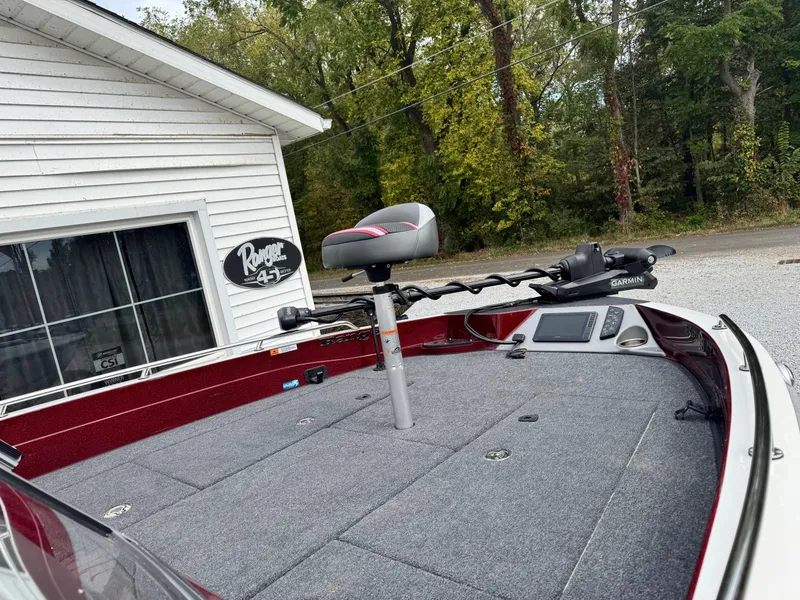 Slide: The Image of 2025 Ranger 620FS boat with fishing equipment, parked near a white building. - 6