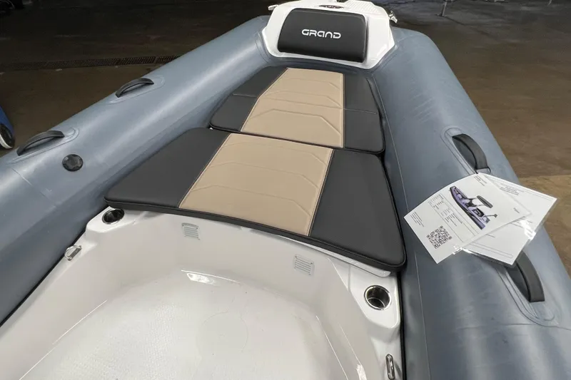 Slide: The Image of 2025 Grand G680 inflatable boat interior with cushioned seating and brochures. - 4