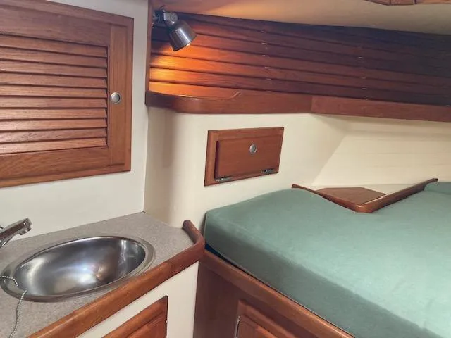 Slide: The Image of Interior of 1997 Pacific Seacraft 40 sailboat with wooden cabinetry and compact sink. - 17