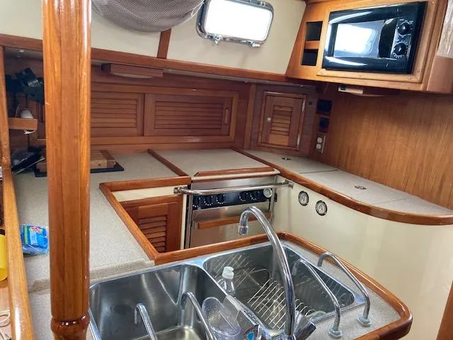 Slide: The Image of Interior view of 1997 Pacific Seacraft 40 sailboat kitchen with sink, stove, and microwave. - 21