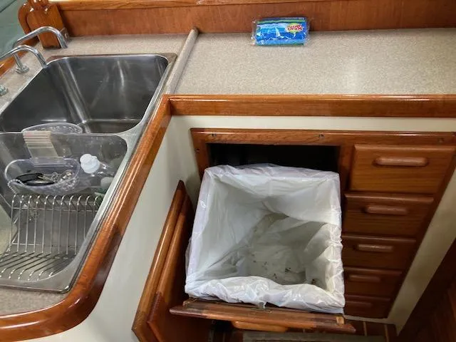 Slide: The Image of Kitchen area of a 1997 Pacific Seacraft 40 sailboat with sink and trash bin. - 24
