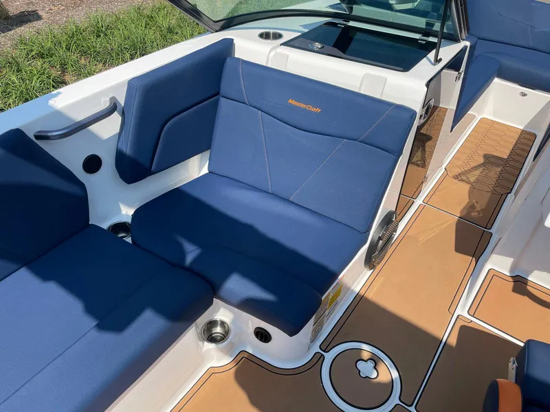 Slide: The Image of 2021 MasterCraft NXT 24 boat interior with blue seating and tan flooring. - 11