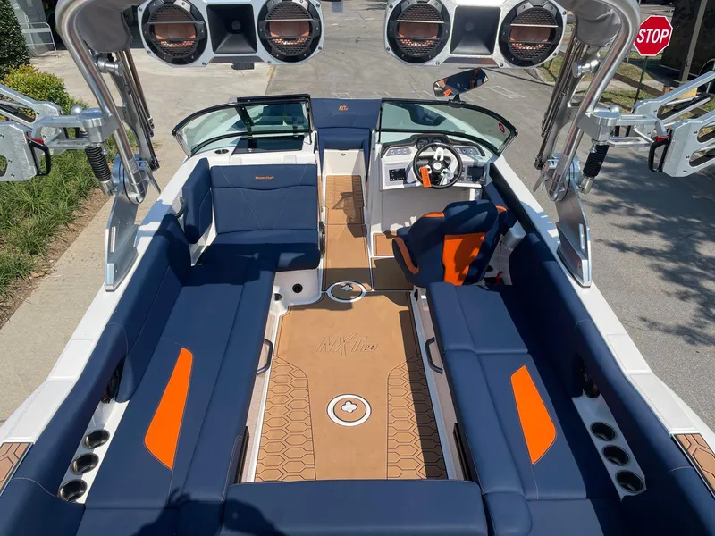 Slide: The Image of 2021 MasterCraft NXT 24 boat interior with blue and orange seating, advanced audio system. - 12