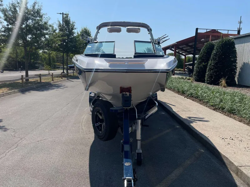 Slide: The Image of 2021 MasterCraft NXT 24 boat on trailer, parked outdoors on a sunny day. - 7