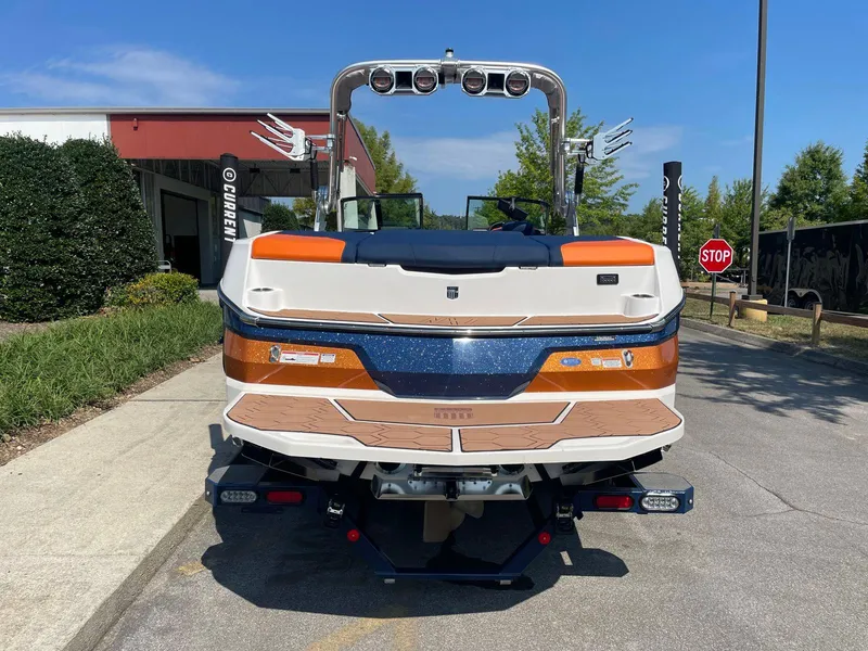 Slide: The Image of 2021 MasterCraft NXT 24 boat, rear view, parked outdoors on a sunny day. - 8