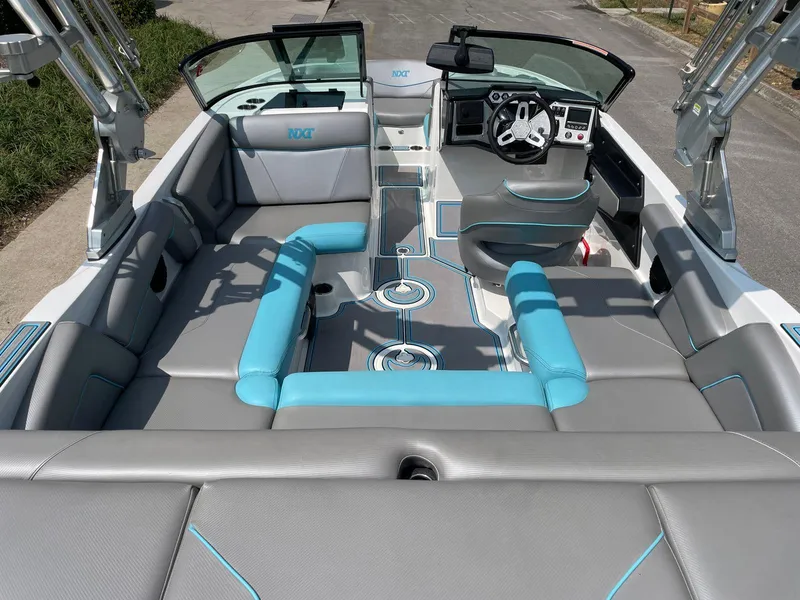 Slide: The Image of 2018 MasterCraft NXT20 boat interior with gray and blue seating, modern dashboard, and open layout. - 11