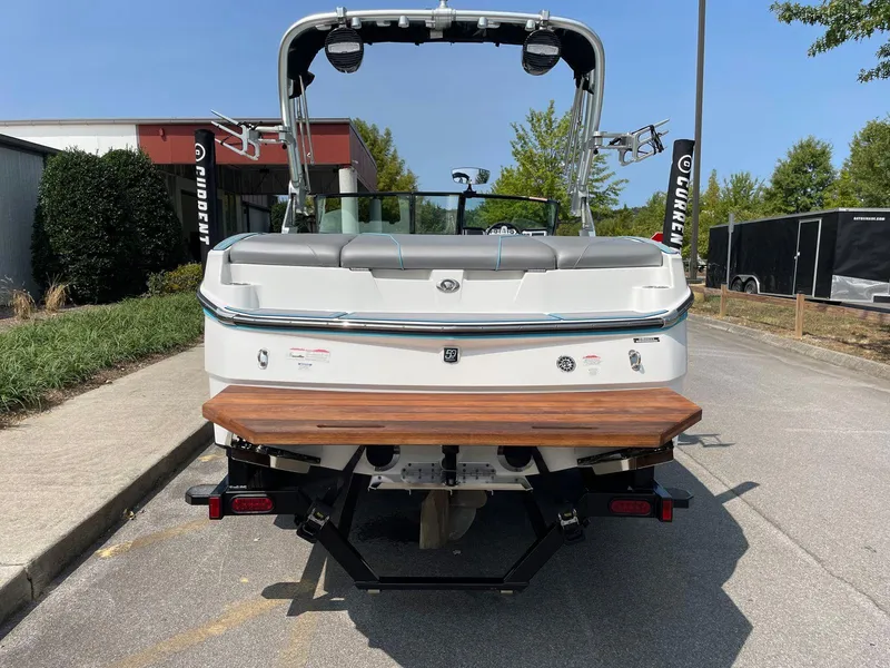 Slide: The Image of 2018 MasterCraft NXT20 boat rear view with swim platform, parked outdoors. - 7