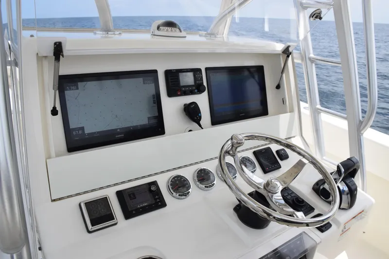 Slide: The Image of 2020 SeaVee 370z helm with navigation screens and steering wheel, ocean view. - 20