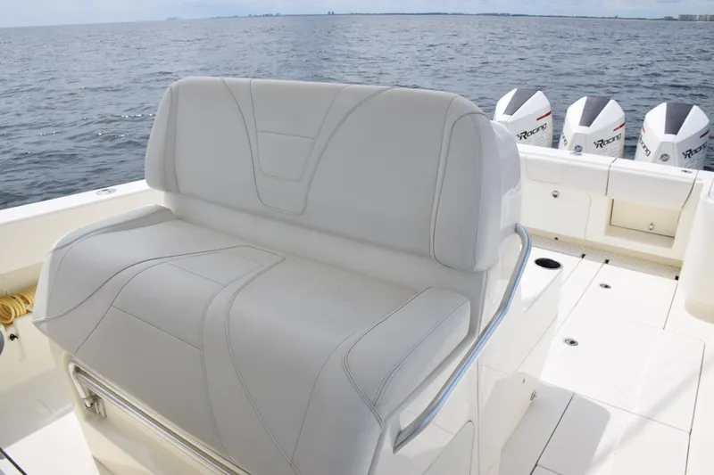 Slide: The Image of SeaVee 370z 2020 boat with cushioned seating and triple outboard motors on open water. - 24