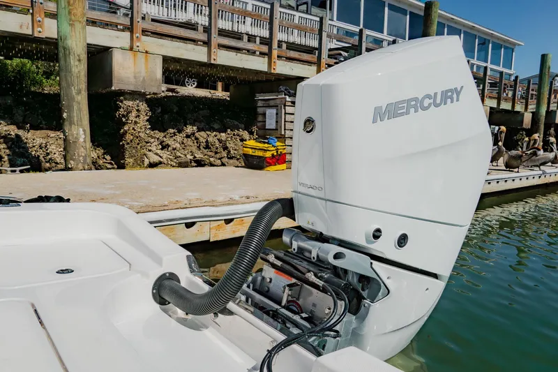 Slide: The Image of 2024 Blackwater 23 Hybrid boat with Mercury outboard engine docked by a wooden pier. - 12