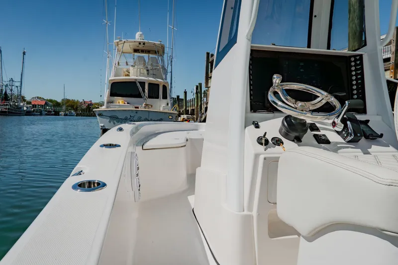 Slide: The Image of 2024 Blackwater 23 Hybrid boat, sleek design, docked in marina, clear blue sky. - 16