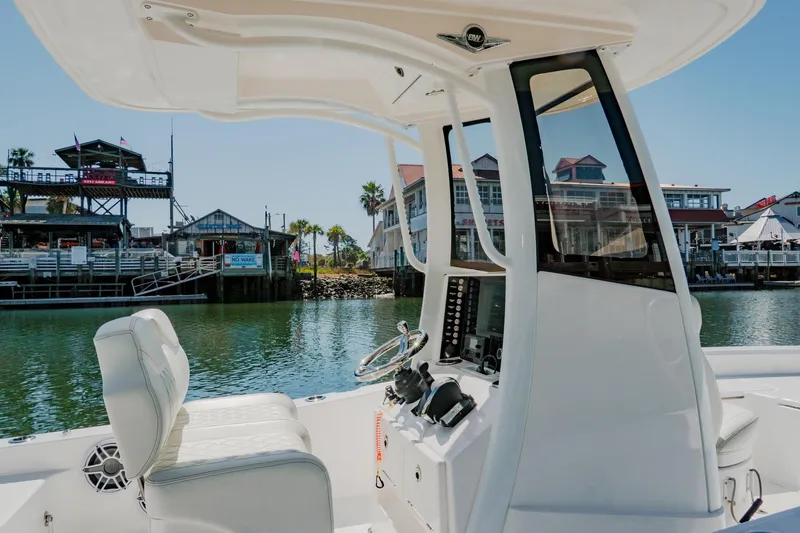 Slide: The Image of 2024 Blackwater 23 Hybrid boat interior with waterfront view and marina buildings. - 18