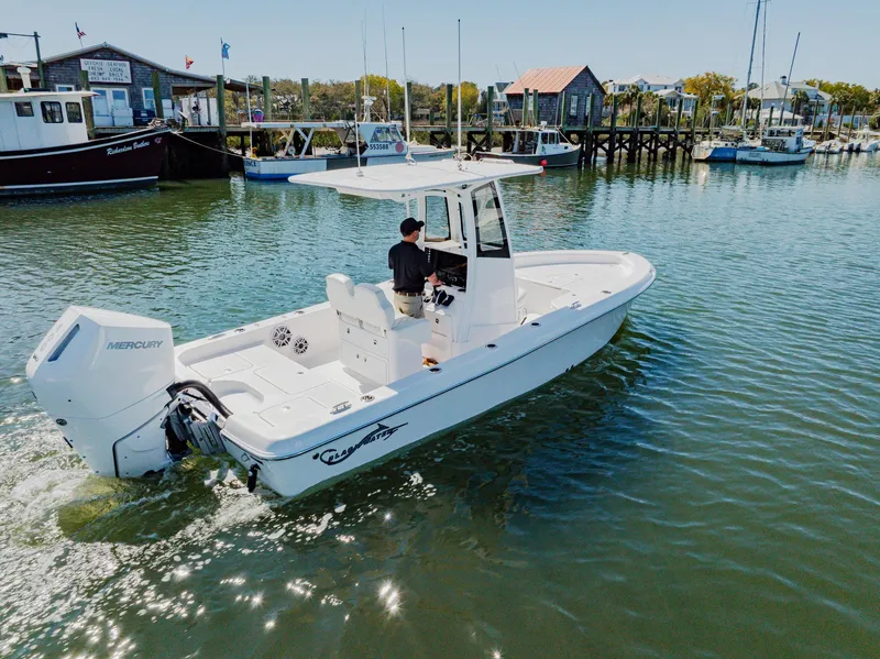 Slide: The Image of 2024 Blackwater 23 Hybrid boat cruising in a marina with a Mercury engine. - 5