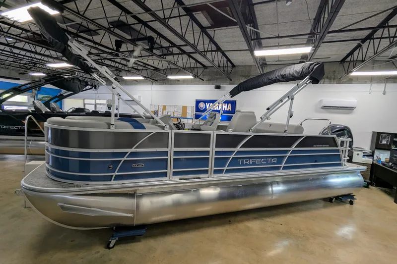 The Image of 2025 Trifecta 22UL LE T pontoon boat with Yamaha motor, parked on blocks. - 0
