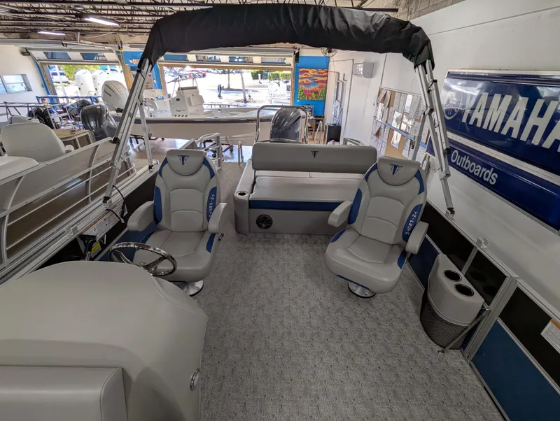 Slide: The Image of 2025 Trifecta 22UL LE T pontoon boat with cover, parked outdoors. - 10