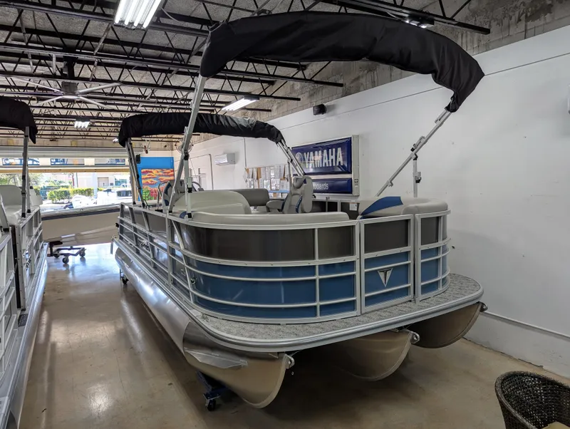 Slide: The Image of 2025 Trifecta 22UL LE T pontoon boat in showroom, featuring sleek design and modern amenities. - 3