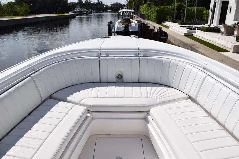 Slide: The Image of 2017 Intrepid 327 boat with white seating, docked by a canal. - 11