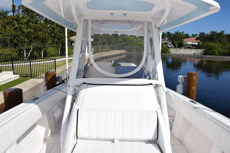 Slide: The Image of 2017 Intrepid 327 boat with white seating, docked by a calm canal. - 14